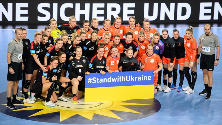 Both handball teams posed behind a sign saying &#39;stand with Ukraine&#39; after the match.