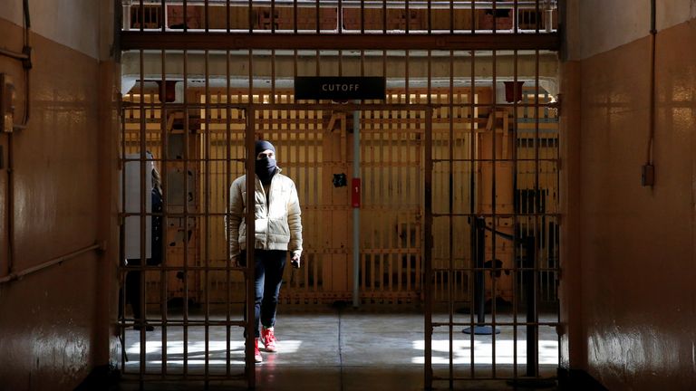 A visitor listens to self-guided audio tours in the main cell house as Alcatraz Island and the famous former prison reopens to the public for indoor tours, after being forced to shut down twice over the past year due to the coronavirus disease (COVID-19) pandemic, in San Francisco Bay, California, U.S. March 15, 2021. REUTERS/Brittany Hosea-Small
