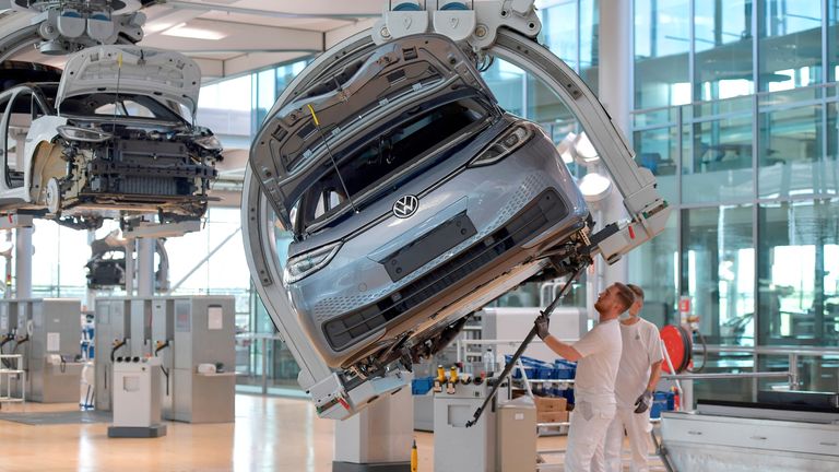 FILE PHOTO: Technicians work in the assembly line of German carmaker Volkswagen&#39;s electric ID. 3 car in Dresden, Germany, June 8, 2021. 