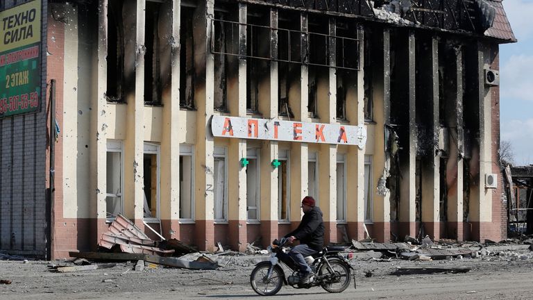 Un résident local passe en scooter devant un bâtiment endommagé pendant le conflit entre l'Ukraine et la Russie dans la ville de Volnovakha, contrôlée par les séparatistes, dans la région de Donetsk, en Ukraine, le 15 mars 2022. REUTERS/Alexander Ermochenko