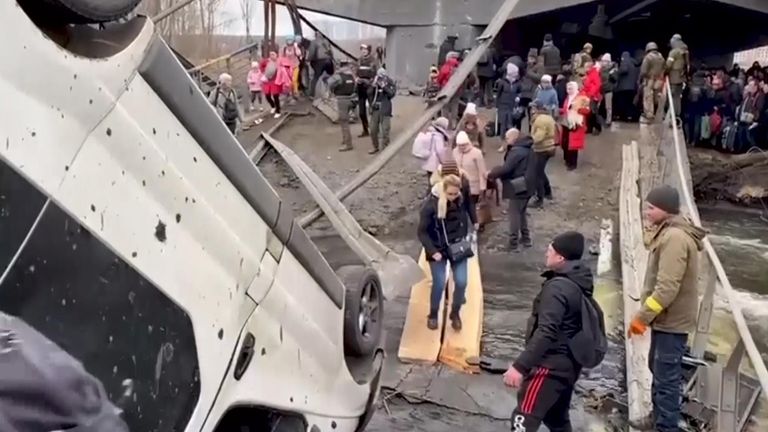 A makeshift walkway for fleeing civilians was hastily built after a bridge linking Irpin and Kyiv was bombed

They carried whatever they could - many jus