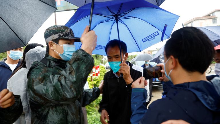 A man surnamed Ding, relative of a victim, arrives at the entrance of Lu village near the site where a China Eastern Airlines Boeing 737-800 plane flying from Kunming to Guangzhou crashed, in Wuzhou, Guangxi Zhuang Autonomous Region, China March 23, 2022. REUTERS/Carlos Garcia Rawlins

