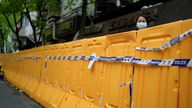 FILE PHOTO: A woman looks over a barrier at an area under lockdown amid the coronavirus disease (COVID-19) pandemic, in Shanghai, China April 13, 2022. REUTERS/Aly Song/File Photo
