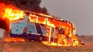 A tourist bus bursts into flames after it collided with a truck 