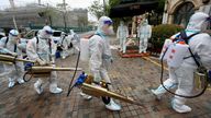 Volunteers in protective suits prepare to disinfect a residential compound in Huangpu district to tackle COVID outbreak in Shanghai