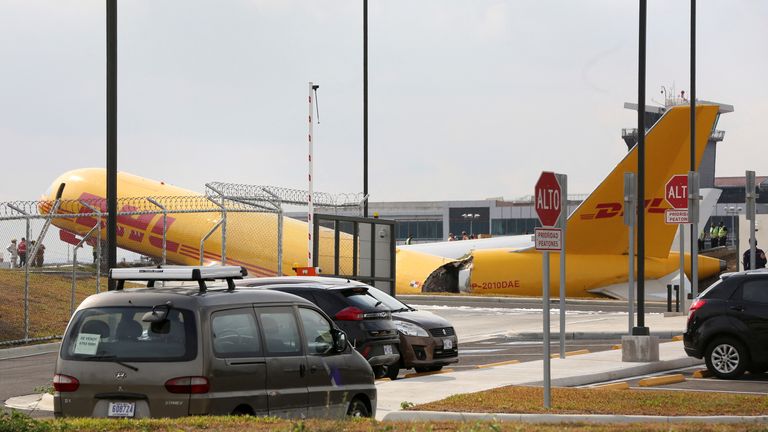 Firefighters work at the scene where a Boeing 757-200 cargo aircraft operated by DHL made an emergency landing before skidding off the runway and splitting, aviation authorities said, at the Juan Santamaria International Airport in Alajuela, Costa Rica April 7, 2022. REUTERS/Mayela Lopez
