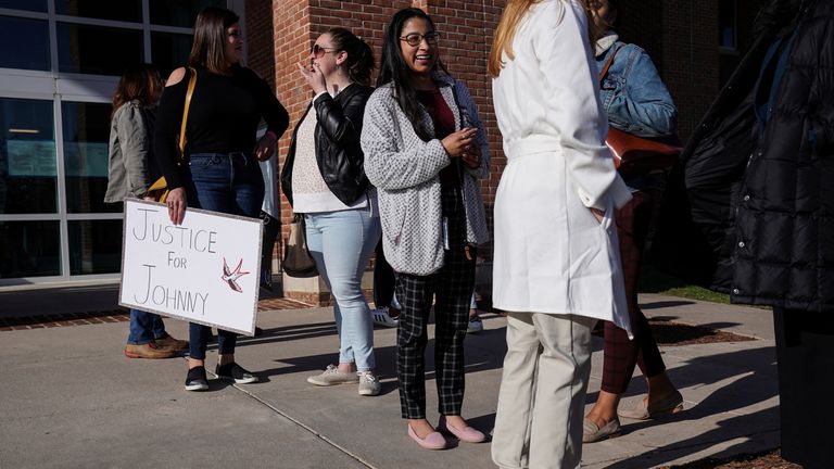 Supporters gather and hold a poster outside of the Fairfax County Circuit Courthouse, before jury selection in the Johnny Depp defamation case against Amber Heard, in Fairfax, Virginia, U.S., April 11, 2022. REUTERS/Sarah Silbiger