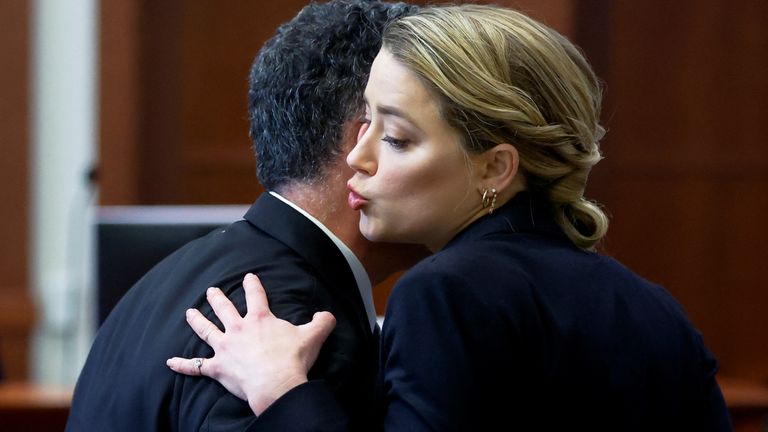 Actor Amber Heard greets a member of her legal team during her ex-husband Johnny Depp&#39;s defamation trial against her, at the Fairfax County Circuit Courthouse in Fairfax, Virginia, U.S., April 27, 2022. REUTERS/Jonathan Ernst/Pool

