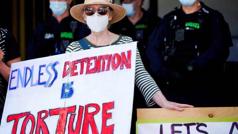 A pro-refugee protestor demonstrates in front of the guarded Park Hotel, where Serbian tennis player Novak Djokovic later arrived for detention in federal custody, in Melbourne, Australia, January 15, 2022. REUTERS/Sandra Sanders
