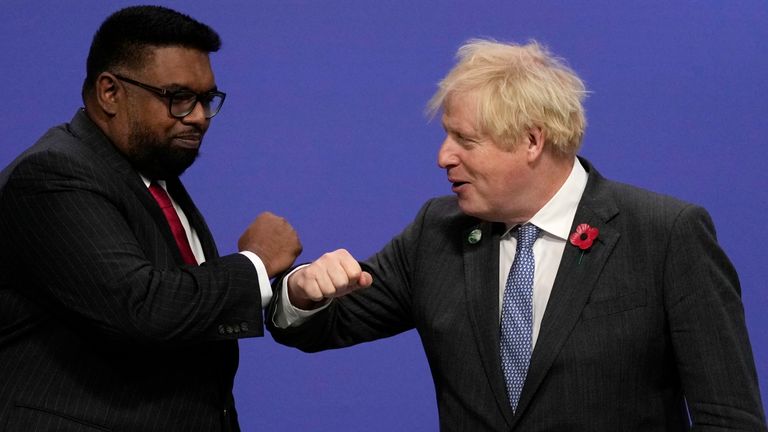 British Prime Minister Boris Johnson, right, greets Guyana&#39;s President Irfaan Ali during arrivals at the COP26 U.N. Climate Summit in Glasgow, Scotland