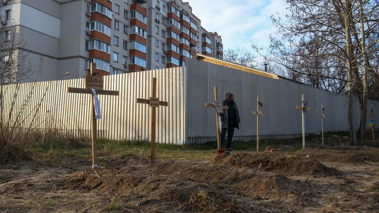 4 Nisan 2022, Ukrayna'nın Kiev bölgesinde, Bucha'da, Rusya'nın Ukrayna'ya saldırısı devam ederken, yerel sakinlere göre Rus askerleri tarafından öldürülen sivillerin cesetlerinin bulunduğu mezarların yanında bir adam duruyor. REUTERS/Vladyslav Musiienko