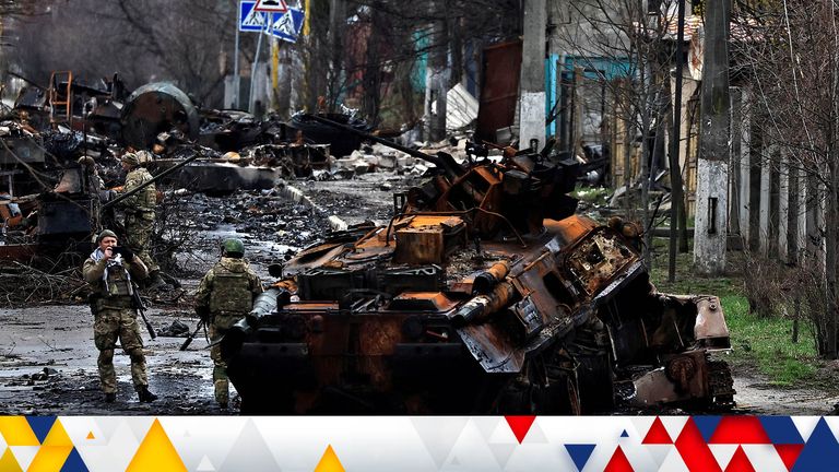 A soldier takes a photograph of his comrade as he poses beside a destroyed Russian tank and armoured vehicles, amid Russia&#39;s invasion on Ukraine in Bucha, in Kyiv region, Ukraine April 2, 2022. REUTERS/Zohra Bensemra    