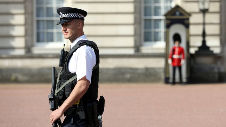 A police officer patrols the grounds of Buckingham Palace