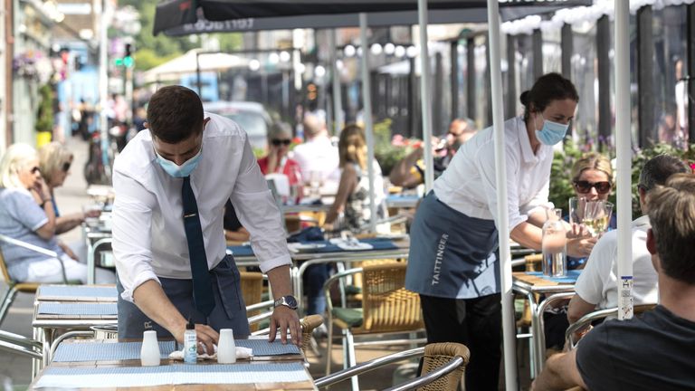 A waiter setting a table, as three out of four workers are considering a new job because of the cost-of-living crisis, new research suggests.