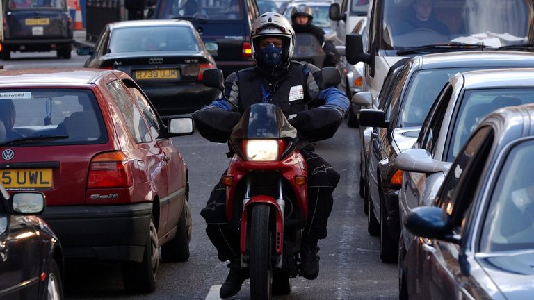 A motorcyclist makes his way through a traffic jam in central London, February 26, 2002. London Mayor Ken Livingstone said on Tuesday that a daily charge of GBP5 (USD7) would be levied on motorists driving into the heart of the capital between 0700 GMT and 1830 GMT from early next year in an attempt to ease congestion on the roads. REUTERS/Stephen Hird SH/ASA