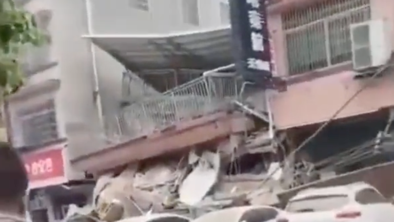 Footage on social media showed people stood watching in shock as the building collapsed. Pic: Twitter @LovingChinaMI. 