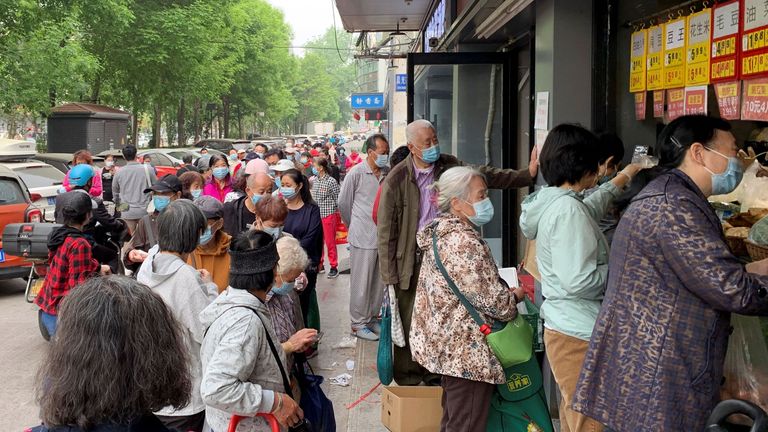Residents wearing face masks line up to get food supplies from a grocery store following the coronavirus disease (COVID-19) outbreak in Chaoyang district of Beijing, China April 25, 2022. REUTERS/Xiaoyu Yin
