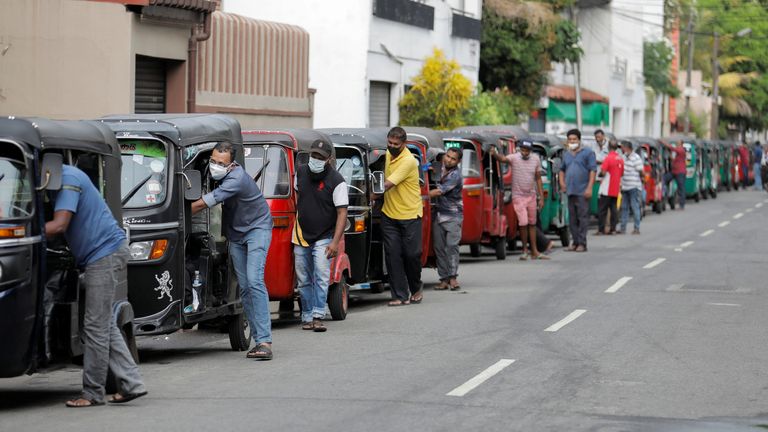 Drivers push their three-wheelers while waiting in a line to buy petrol at a Ceylon Ceypetco fuel station on a main road, amid the country&#39;s economic crisis in Colombo, Sri Lanka, April 12, 2022. REUTERS/Dinuka Liyanawatte
