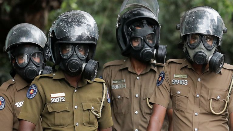 Sri Lanka police officers wearing gas masks stand guard on a road leading to the parliament building, after the government of President Gotabaya Rajapaksa lost its majority, amid the country&#39;s economic crisis, in Colombo, Sri Lanka, April 5, 2022. REUTERS/Dinuka Liyanawatte
