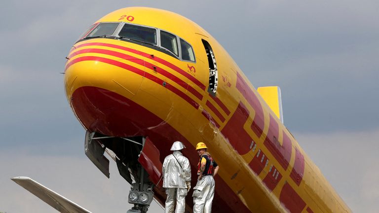 Firefighters stand at the scene where a Boeing 757-200 cargo aircraft operated by DHL made an emergency landing before skidding off the runway and splitting, aviation authorities said, at the Juan Santamaria International Airport in Alajuela, Costa Rica April 7, 2022. REUTERS/Mayela Lopez TPX IMAGES OF THE DAY
