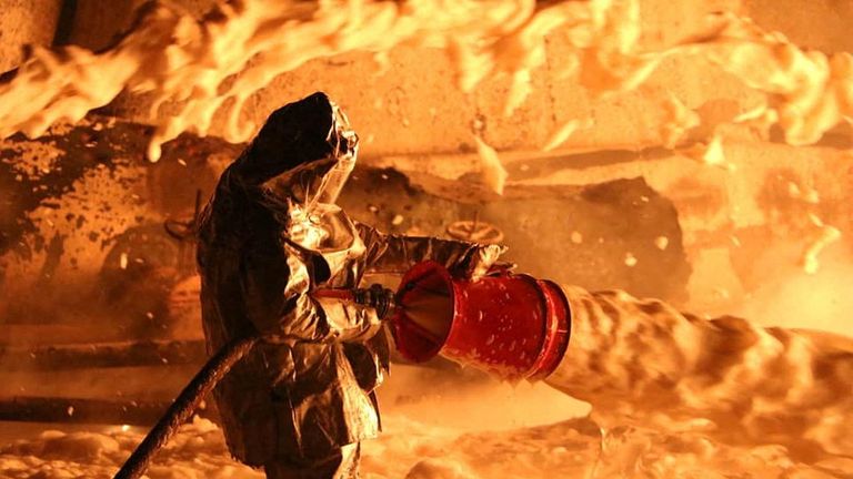 A firefighter works at a site of burning fuel storage facilities damaged by an airstrike in Dnipropetrovsk region

