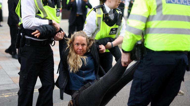 An activist is carried away by police officers at an Extinction Rebellion protest outside Shell&#39;s headquarters in London, Britain, April 13, 2022. REUTERS/Hannah McKay
