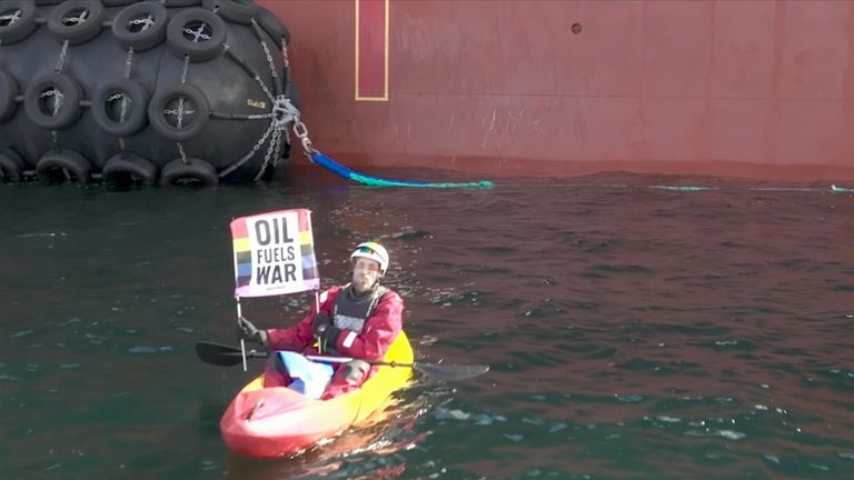 Protesters sail alongside an enormous Russian tanker in Danish waters