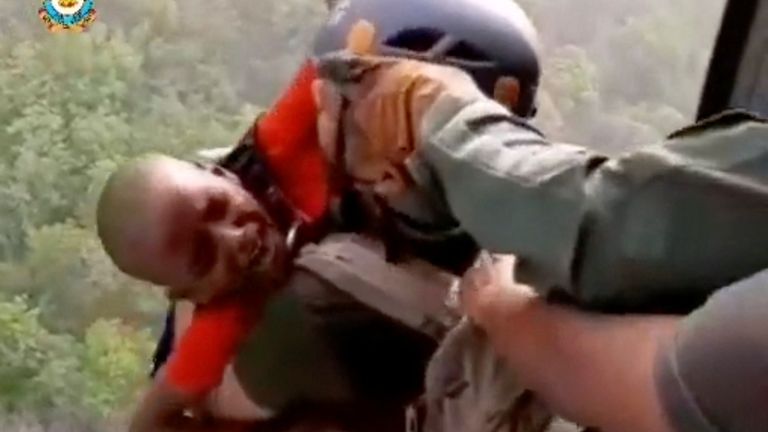 A rescuer carries a child to a helicopter during a rescue operation after a mid-air collision of two cable cars on Sunday trapped nearly 50 people in a dozen cars, in Deoghar district, Jharkhand state, India in this still image taken from a handout video obtained April 12, 2022. Courtesy Indian Air Force/Handout via REUTERS THIS IMAGE HAS BEEN SUPPLIED BY A THIRD PARTY. MANDATORY CREDIT
