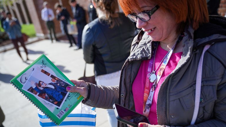 A supporter holds printed photos to be signed outside of the Fairfax County Circuit Courthouse, before jury selection in the Johnny Depp defamation case against Amber Heard, in Fairfax, Virginia, U.S., April 11, 2022. REUTERS/Sarah Silbiger 