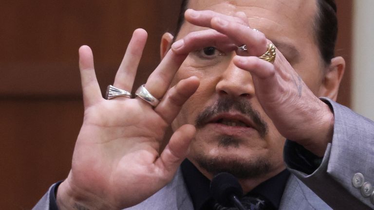Actor Johnny Depp displays the middle finger of his hand, injured while he and his ex-wife Amber Heard were in Australia in 2015, as he testifies during his defamation trial against Heard at the Fairfax County Circuit Courthouse in Fairfax, Virginia, U.S., April 20, 2022. REUTERS/Evelyn Hockstein/Pool
