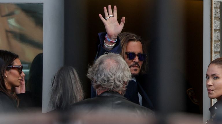 Johnny Depp waves as he enters the Fairfax County Judicial Center for the defamation case against Amber Heard in Fairfax, Virginia, U.S., April 12, 2022. REUTERS/Evelyn Hockstein
