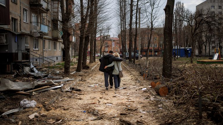 A couple hugs while walking past a building that was heavily damaged by shelling, as Russia&#39;s attack on Ukraine continues, in Kharkiv, Ukraine, April 10, 2022. REUTERS/Alkis Konstantinidis TPX IMAGES OF THE DAY
