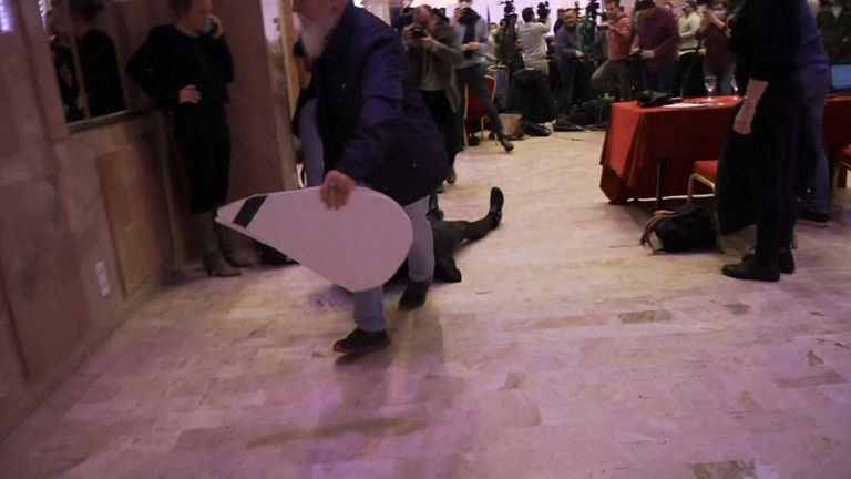 Protestocu, tabelayı tuttuktan sonra odadan sürüklenerek çıkarıldı.  Resim: BFM