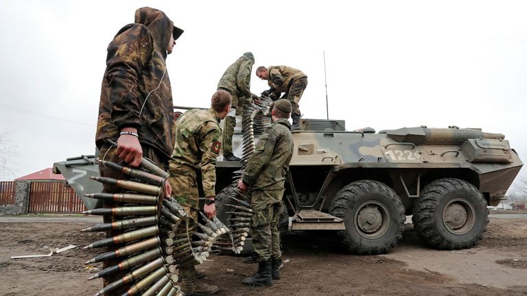 Service members of pro-Russian troops load ammunition into an armoured personnel carrier  in  Mariupol on 12 April