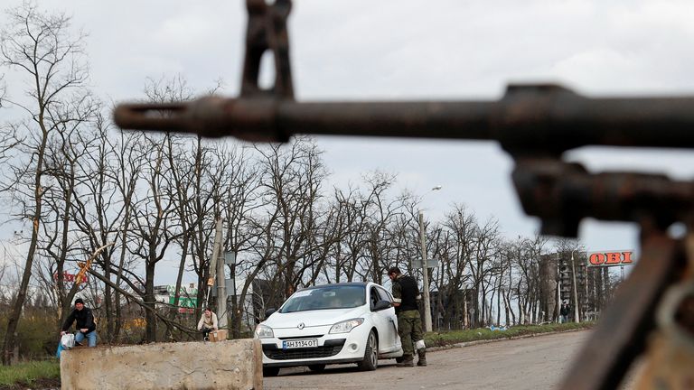 A service member of pro-Russian troops stands guard at a checkpoint in Mariupol