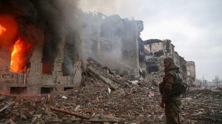 A service member of pro-Russian troops stands in front of the destroyed administration building of Azovstal Iron and Steel Works during Ukraine-Russia conflict in the southern port city of Mariupol, Ukraine April 21, 2022. REUTERS/Chingis Kondarov
