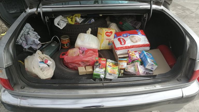 Aleksey fills his car with provisions to bring to people in need: eggs, food for the children, bottles of water.  He says food for the under-ones is particularly scarce.