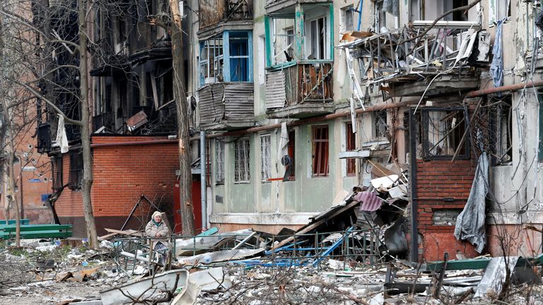 A local resident sits on a bench in a courtyard damaged during Ukraine-Russia conflict in the southern port city of Mariupol, Ukraine April 18, 2022. REUTERS/Alexander Ermochenko