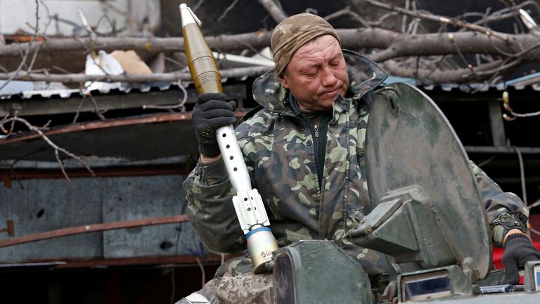 Un combattant pro-russe charge des grenades propulsées par fusée dans un véhicule de combat d'infanterie lors de combats à Marioupol