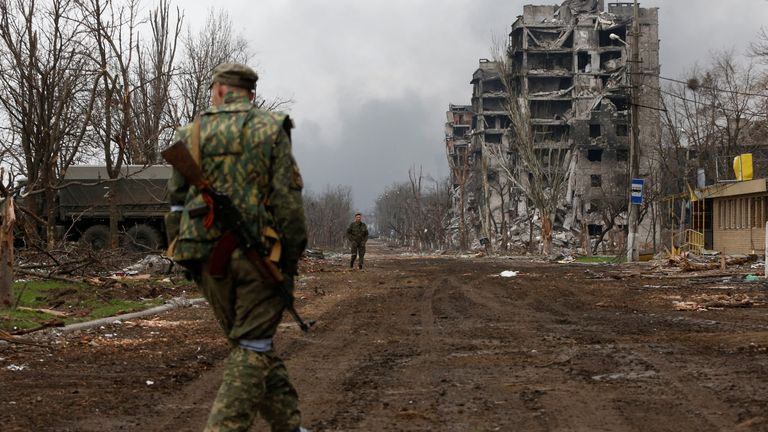 Ukrayna güçleri şehri ele geçirmek için savaşırken, Rus yanlısı bir asker Mariupol sokaklarında yürüyor