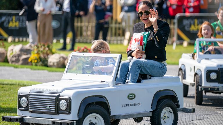 La duchesse de Sussex est conduite par Mya Poirot, 5 ans, dans un jouet Land Rover au Jaguar Land Rover Driving Challenge lors des Jeux Invictus au Zuiderpark de La Haye, aux Pays-Bas.  Date de la photo : samedi 16 avril 2022.


