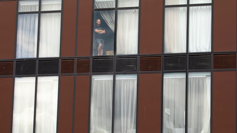 Australian Adam Royter, looks out a window while in quarantine at the Ramada Hotel in Auckland, New Zealand, March 30, 2020. Pic: Brett Phibbs/New Zealand Herald via AP     