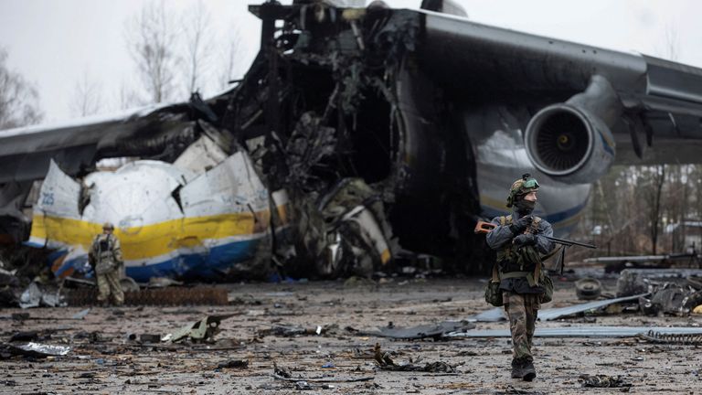 عضو في الخدمة الأوكرانية يسير أمام المطار في مستوطنة هوستوميل أمام أكبر طائرة في العالم ، طائرة الشحن أنتونوف An-225 Mriya ، التي دمرتها القوات الروسية في خضم هجوم روسيا على أوكرانيا.  ، منطقة كييف