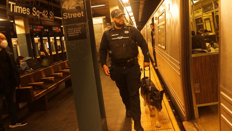 A police officer checks Manhattan subways after a shooting in Brooklyn
