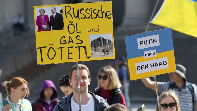 26 mars 2022, Bavière, Munich : des manifestants avec des pancartes lisant "Tuez le pétrole et le gaz russes" et "Poutine à La Haye" se présenter à un rassemblement sous le slogan "Ensemble contre la guerre !" sur K'nigsplatz.  Avec d'autres organisations, les Ukrainiens de Munich et de Bavière, la communauté biélorusse de Munich, le SPD Bavière, Volt Bayern, le FDP Munich et B'ndnis 90/die Gr'nen avaient appelé à la manifestation.  Photo par : Felix H'rhager/picture-alliance/dpa/AP Images