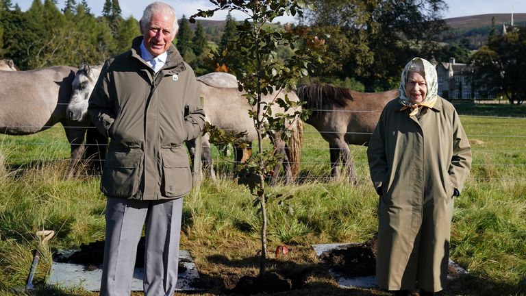 The Queen and Prince Charles  stand next to a tree they planted at the Balmoral Cricket Pavilion in 2021