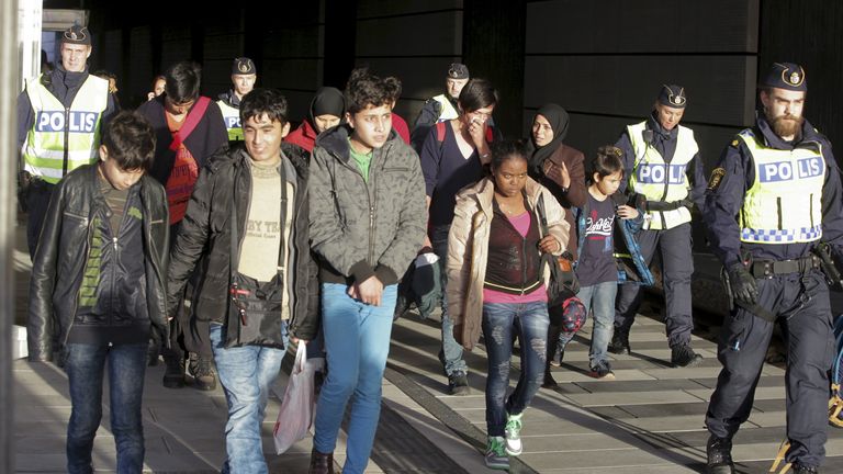 A group of migrants, coming off an incoming train, are seen next to police on the platform at the Swedish end of the bridge between Sweden and Denmark, in Hyllie district, Malmo November 12, 2015. Sweden will impose temporary border controls from Thursday in response to a record influx of refugees, a turnaround for a country known for its open-door policies that also threw down the gauntlet to other EU nations hit by a migration crisis. REUTERS/Stig-Ake Jonsson/TT News AgencyATTENTION EDITORS - 