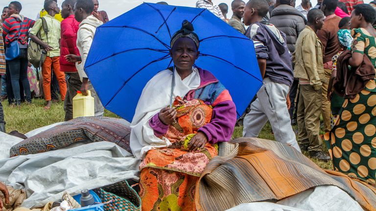 A refugee from the Democratic Republic of Congo sits with her belongings near the United Nations High Commissioner for Refugees (UNHCR) offices in Kiziba refugee camp in Karongi District, Rwanda February 21, 2018. REUTERS/Jean Bizimana
