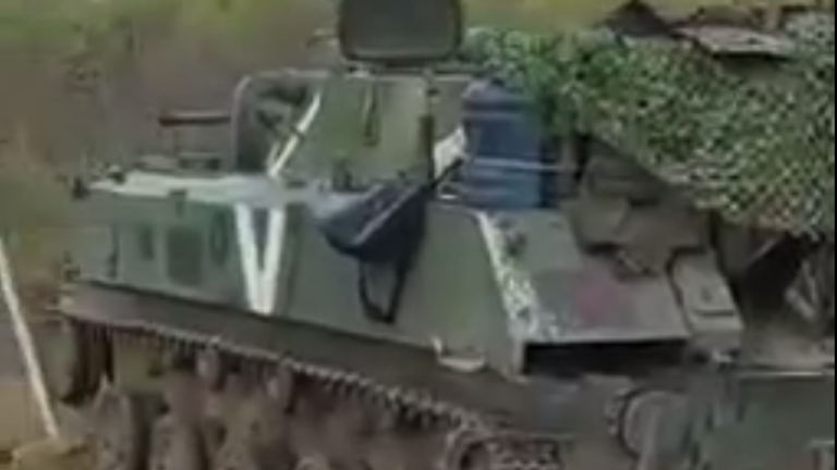 Un vehicul despre care se crede că aparține forțelor armate ruse este văzut abandonat pe marginea drumului în videoclip.