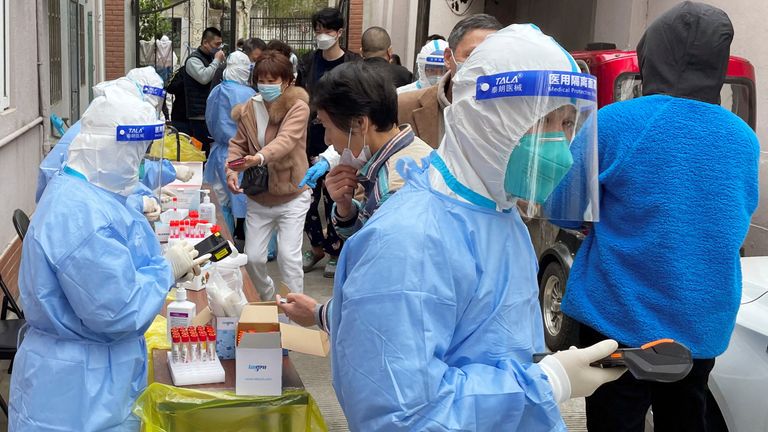 Medical workers in protective suits administer nucleic acid testing for residents in a residential compound, as the second stage of a two-stage lockdown to curb the spread of the coronavirus disease (COVID-19) begins in Shanghai, China April 1, 2022. REUTERS/Brenda Goh